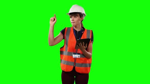 Front view of a site forewoman using digital tablet with green screen