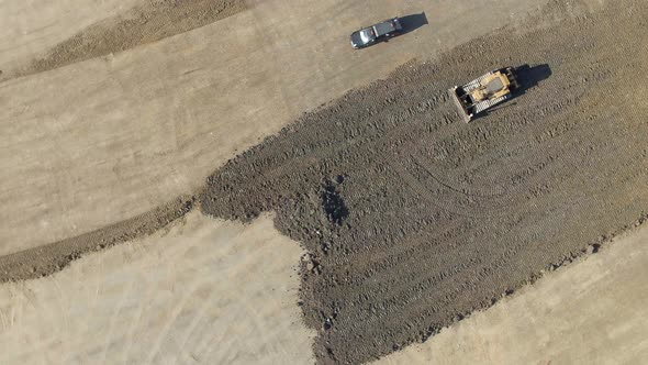 A Bulldozer Moving Earth to Flatten it for Construction