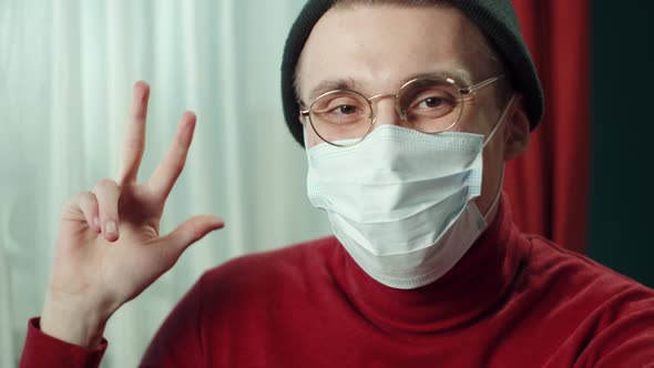 Closeup Face of Cheerful Young Man in Protective Mask Wearing Glasses Hat