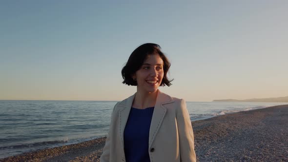 Beautiful Girl Walks at the Beach by the Ocean