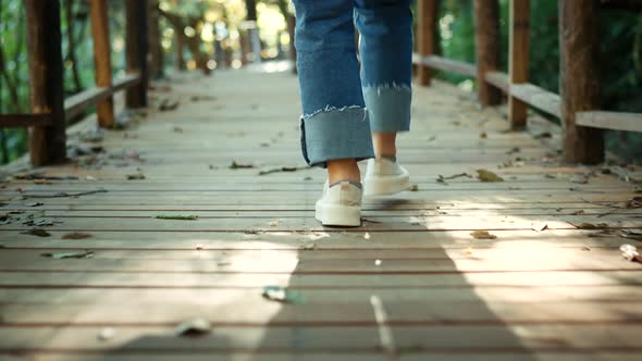 B roll - Woman legs walking on park. Teenager legs on sneakers walking.