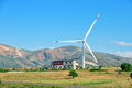Wind turbine and house on hill under blue sky - PhotoDune Item for Sale