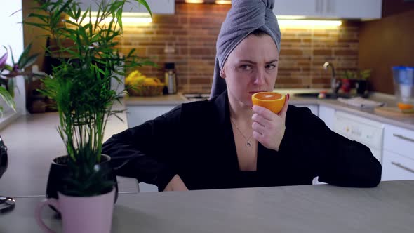 Sick Woman Trying to Sense Smell of Fresh Orange