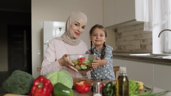 Cute Little Daughter Enjoying Cooking Master Class From Affectionate Young Mother in Hijab