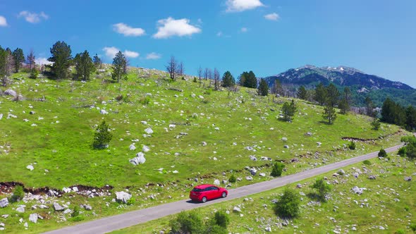 Aerial View of Road with Red Car in Beautiful Mountains in Komovi Montenegro