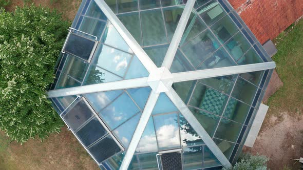 Glass roof of a solar house with hexagonal base. Transparent outer walls in an energy efficient home