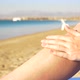 Girl with Beautiful Legs Rubbed Into the Skin Sunscreen on a Sea Background - VideoHive Item for Sale
