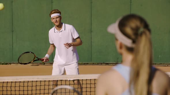 Tennis match between male and female athletes wearing white sportswear, hobby