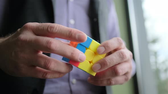 A Businessman Is Solving Rubik's cube.Close-up Man Is Holding Rubik's cube.Brain Training Concept