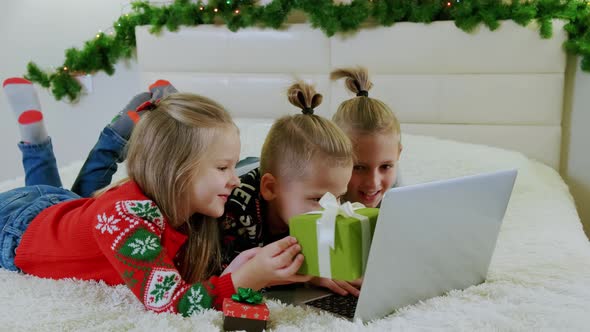 New Year's Concept Children Lie Couch Christmas Clothes Make Online Call Laptop