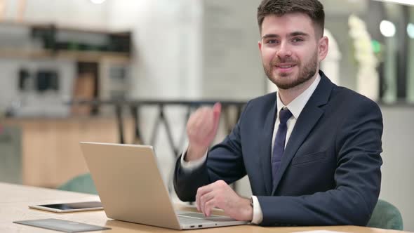 Thumbs Up By Positive Young Businessman Working in Office