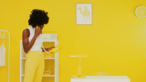 African Woman Is Talking Retro Phone In Yellow Office