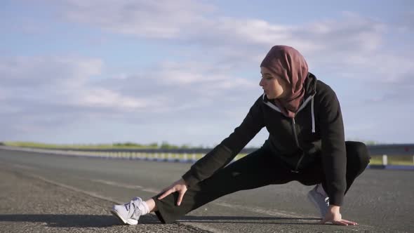Muslim Woman Stretches Her Legs Before Running