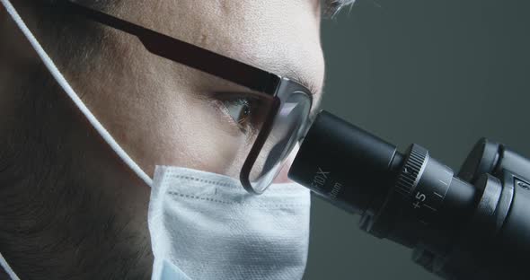 Male Scientist Looking at Microscope