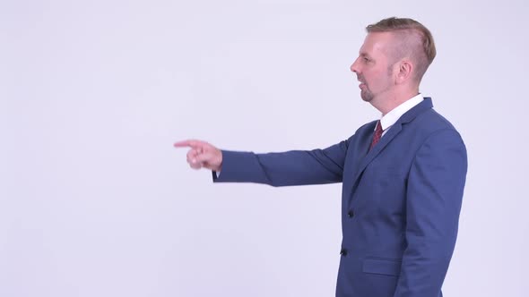 Profile View of Happy Blonde Businessman Pointing Finger