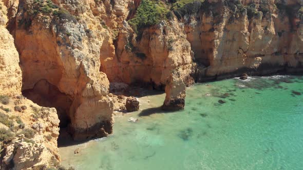 Isolated Rugged Algarve's southern cliffs washed by emerald green sea, Portugal