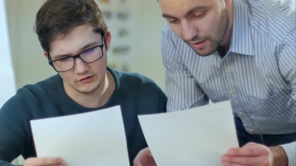 Attentive Boy Studying with a Laptop While Teacher Helping Him