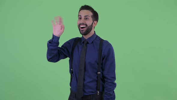 Happy Young Bearded Persian Businessman Waving Hand