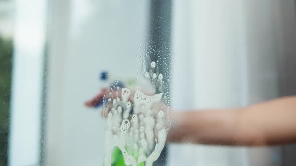 Hand Spraying on Window with Detergent From Dispenser House Cleaning and Washing