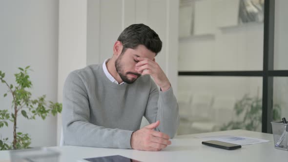 Upset Young Man Feeling Worried While Sitting in Office