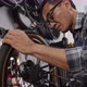 Asian senior man worker repairing and checking wheels and gears of bicycle - VideoHive Item for Sale