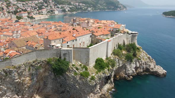 Aerial drone forwarding shot over the old fortress wall along the old town of Dubrovnik, Croatia wit