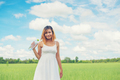 young pretty  woman wearing white dress in grassland smiley to camera look so fresh enjoy and happy. - PhotoDune Item for Sale