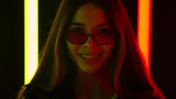 Portrait of a Pretty Young Beautiful Woman in Stylish Sunglasses Looking at the Camera Shows a Heart