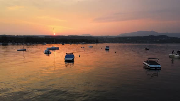Aerial View of Magical Sunset Sun and Orange Sky Reflection of Calm Lake Water. Lago di Garda, Salo,