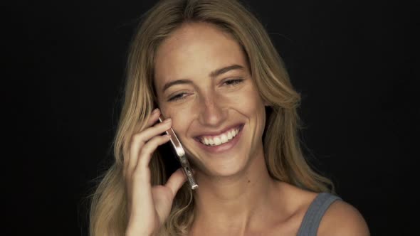 Young woman talking on cell phone and smiling cheerfully