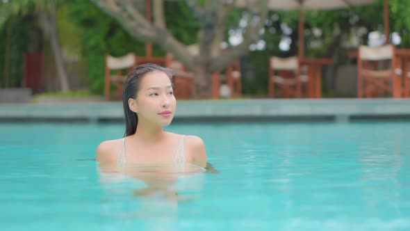 Young asian woman enjoy around outdoor swimming pool for leisure