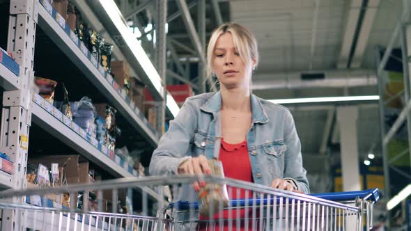 A Woman Takes Packets of Groceries From the Store Shelves