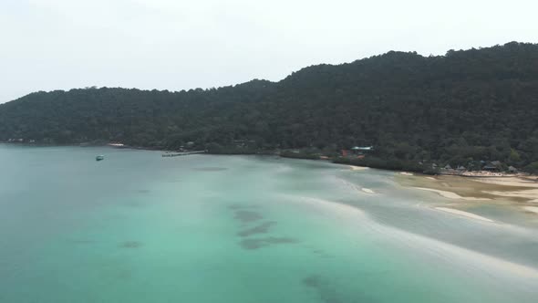 Wide view of Saracen Bay seaside displaying the turquoise shallow waters and tropical vegetation