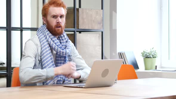 Thumbs Down by Man while Working on Laptop