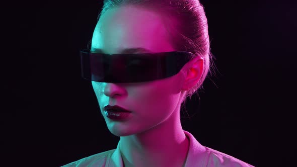 Portrait of teenage girl in cyberpunk style. Young woman posing in futuristic sunglasses.