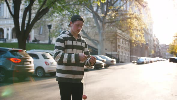 Young Teenage Boy Playing Kendama Outside in City During Beautiful Sunset