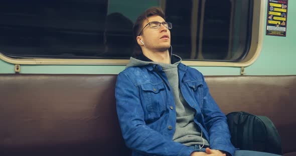 Fashionable Guy Listening to Music with His Eyes Closed in an Empty Car