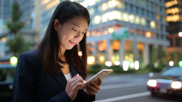 Businesswoman sending sms on cellphone at Tokyo city