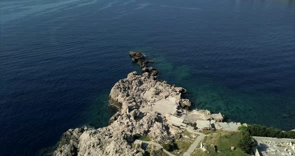 Aerial shot of a Rocky coast in Dubrovnik Croatia. the camera rises to show a wide view of the dista