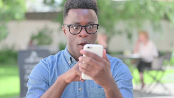 Portrait of African Man Celebrating on Smartphone