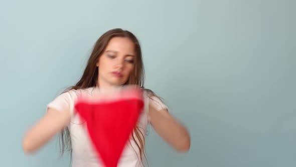 Woman White Tshirt on a Pastel Blue Background Wears a Red Santa Claus Hat for Christmas