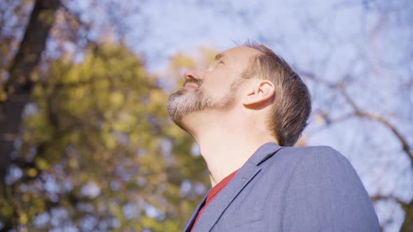 A Middleaged Handsome Caucasian Man Looks Seriously at the Camera in a Park in Fall