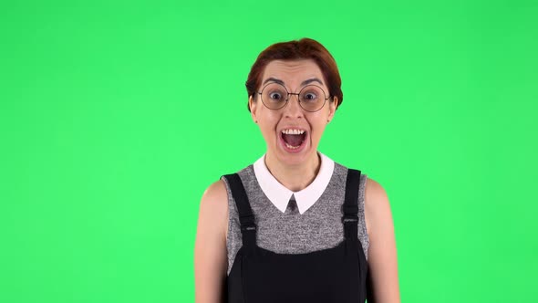 Portrait of Funny Girl in Round Glasses with Shocked Wow Face Expression and Rejoicing, Green Screen