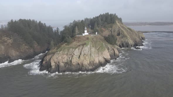 Cape Disappointment Lighthouse sits high above the churning pacific ocean waves, aerial orbit