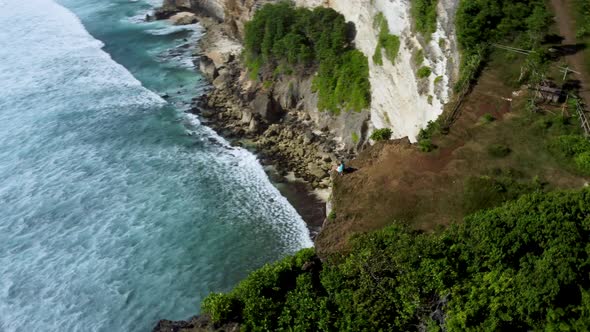 Man Sits on the Clifftop Above Ocean