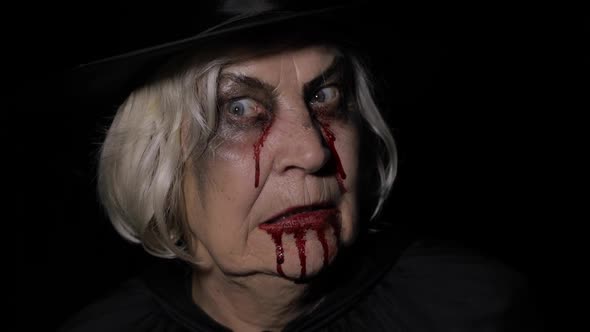 Old Witch Halloween Makeup. Elderly Woman Portrait with Blood on Her Face.