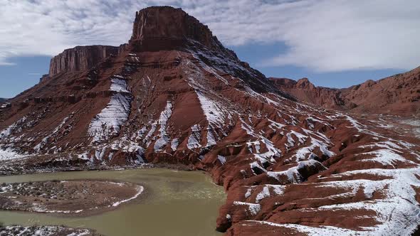 Panning aerial view of red earth landscape with snow melting