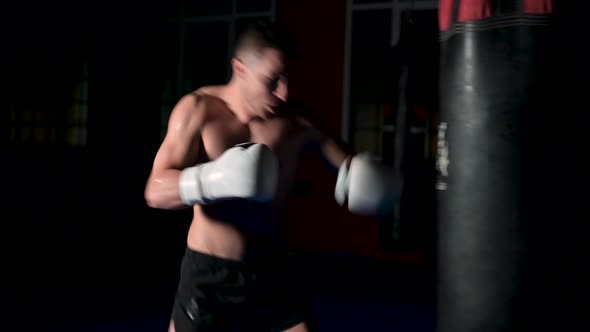 Kickboxing Fighter Trains His Punches and Kicks Beats a Punching Bag Training Day in the Boxing Gym