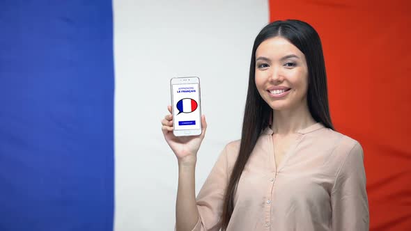 Woman With Smartphone Against French Flag Background, Language Study App