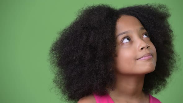 Young Cute African Girl with Afro Hair Thinking While Looking Up